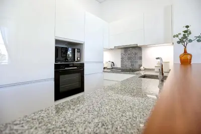 a kitchen with white cabinets and a counter top at Nap in the shade Apartment in Faro