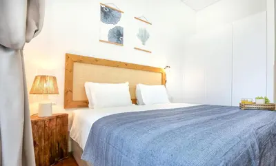 a bedroom with a large bed with a blue blanket at Maison Faro Luxe - A Tranquil Retreat by the Algarve Coast in Faro