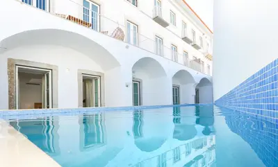 a swimming pool in front of a building at Maison Faro Luxe - A Tranquil Retreat by the Algarve Coast in Faro