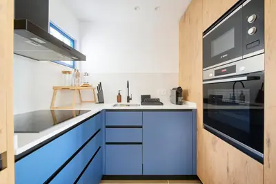 a kitchen with blue cabinets and a microwave at Amazing Flat, 100m from beach in Quarteira