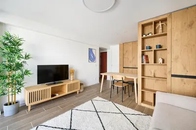 a living room with a television and a table at Amazing Flat, 100m from beach in Quarteira