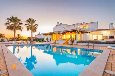 a villa with a swimming pool in front of a house at Villa Serena by Algarve Vacation in Guia