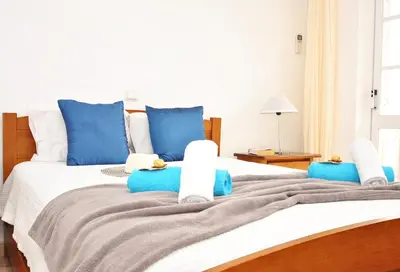 a bedroom with a large bed with blue pillows at Villa Puerto Rico by Algarve Vacation in Albufeira