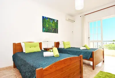 a bedroom with two beds with green pillows at Villa Puerto Rico by Algarve Vacation in Albufeira
