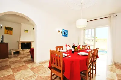 a dining room with a red table and chairs at Villa Puerto Rico by Algarve Vacation in Albufeira