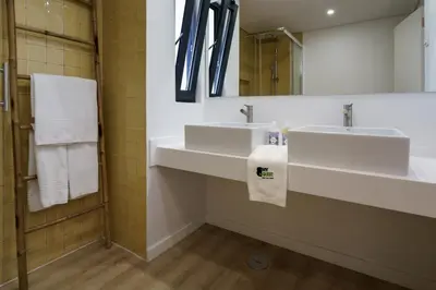 a bathroom with two white sinks and a mirror at BmyGuest Collection - Quinta do Lago Luxury Beach Apartment in Almancil