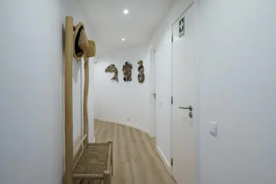 a hallway with white walls and a wooden floor at BmyGuest Collection - Quinta do Lago Luxury Beach Apartment in Almancil