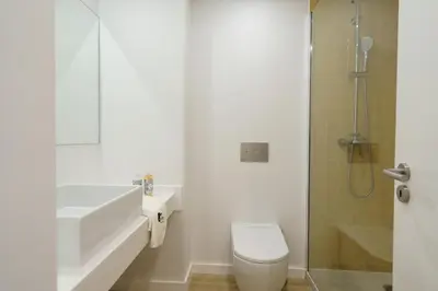 a bathroom with a toilet and a sink and a shower at BmyGuest Collection - Quinta do Lago Luxury Beach Apartment in Almancil