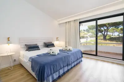 a bedroom with a large bed with two towels on it at BmyGuest Collection - Quinta do Lago Luxury Beach Apartment in Almancil