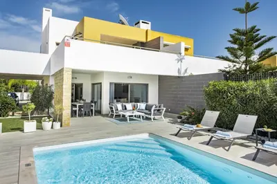 a villa with a swimming pool in front of a house at Blue by Algarve Villa Holidays in Albufeira