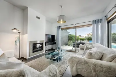 a living room with white furniture and a fireplace at Blue by Algarve Villa Holidays in Albufeira