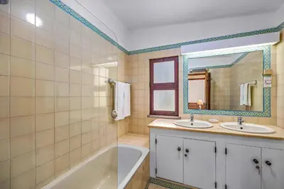 a bathroom with two sinks and a tub and a mirror at Villa Casa Jasmim by Villa Plus in Quarteira