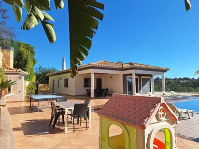 a house with a backyard with a table and chairs at Villa Monte Avós by Ecovillas Albufeira in Albufeira