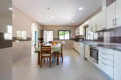 a large kitchen with a table and chairs in it at Villa Monte Avós by Ecovillas Albufeira in Albufeira