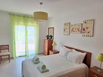 a bedroom with a bed and a large window at Villa Monte Avós by Ecovillas Albufeira in Albufeira