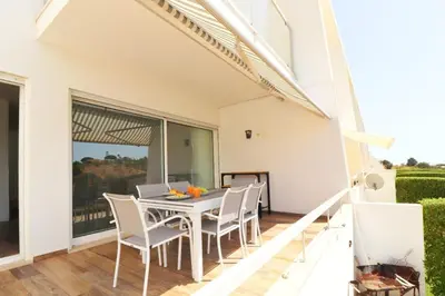 a dining room with a table with chairs and a laptop at Serenity 18 House by Stay ici Algarve Holiday Rental in Albufeira