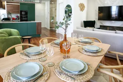 a dining room table with plates and wine glasses at Green Essence Duplex in Faro by Misha's Place in Faro