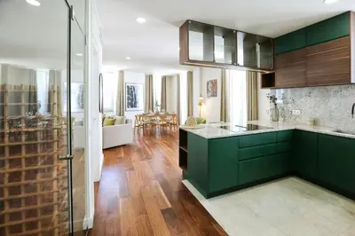 a kitchen with green cabinets and a living room at Green Essence Duplex in Faro by Misha's Place in Faro