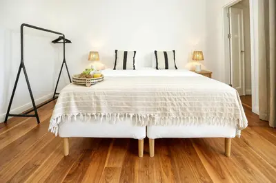 a bedroom with a white bed with black pillows at Green Essence Duplex in Faro by Misha's Place in Faro
