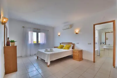 a white bedroom with a bed and a mirror at Villa Santa Maria Valley - Private Pool in Albufeira