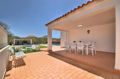 a patio with white chairs and a table on a patio at Villa Santa Maria Valley - Private Pool in Albufeira
