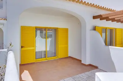 a room with yellow doors in a white building at Side Villas - 1bdr Retreat with BBQ & Patio in Quarteira