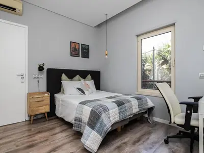 a bedroom with a bed and a desk and a window at Villa Ada in Faro