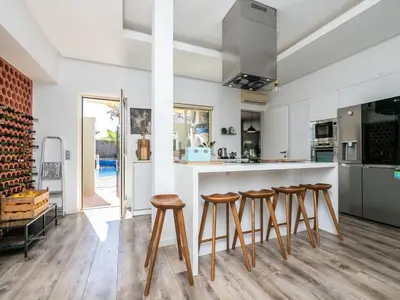 a kitchen with wooden stools at a counter at Villa Ada in Faro
