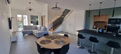 a kitchen and a living room with a table and chairs at T2 Marina Vilamoura in Quarteira