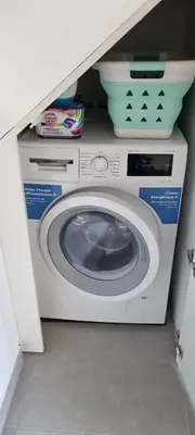 a washer and dryer in a room with a shelf at T2 Marina Vilamoura in Quarteira