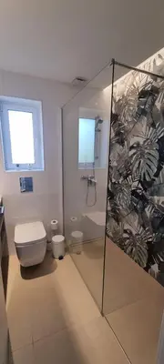a bathroom with a shower and a toilet and a window at T2 Marina Vilamoura in Quarteira
