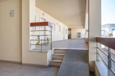 a large swimming pool with palm trees in front of a building at BnB Homes Apartment with cozy Terrace & 2 Swimming pools near the heart city in Albufeira