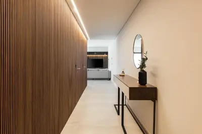 a hallway with a mirror and a wooden wall at Terracos de Quarteira -Luxury Duplex Penthouse 3BR Best View, 50m from Beach in Quarteira