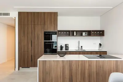 a kitchen with wooden cabinets and a counter top at Terracos de Quarteira -Luxury Duplex Penthouse 3BR Best View, 50m from Beach in Quarteira