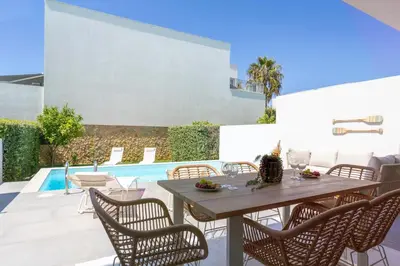 a patio with a table and chairs and a pool at Stylish 3-Bedroom Villa Haven with a Private Pool in Albufeira