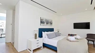 a white bedroom with a bed and a chair at Villa Malibu - Onesix2, Cleverdetails CD 285 in Vilamoura