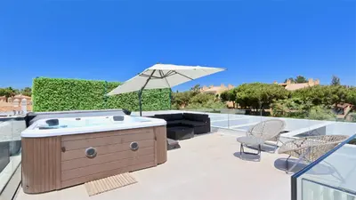a hot tub with an umbrella on a patio at Villa Malibu - Onesix2, Cleverdetails CD 285 in Vilamoura