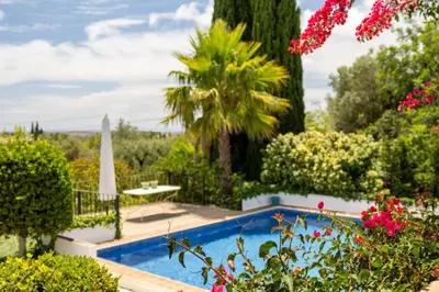 a garden with a swimming pool and flowers at Almancil Sea and Countryside Secluded Villa in Quartos