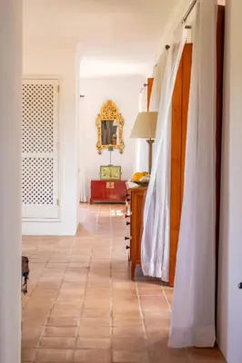 a bedroom with a bed and a chair and a mirror at Almancil Sea and Countryside Secluded Villa in Quartos