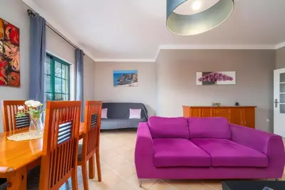 a living room with a purple couch and a table at Calm Paradise close to the City in Faro