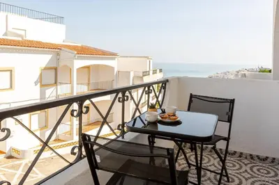 a table and chairs on a balcony with the ocean at BrisaMar Villas 2 Sol Mar Serenidade in Albufeira