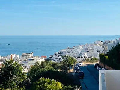 a view of a street with white buildings and the ocean at BrisaMar Villas 2 Sol Mar Serenidade in Albufeira