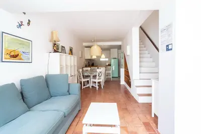 a living room with a blue couch and a table at Villa Mar e Sol by HelloVacations in Olhos de Água