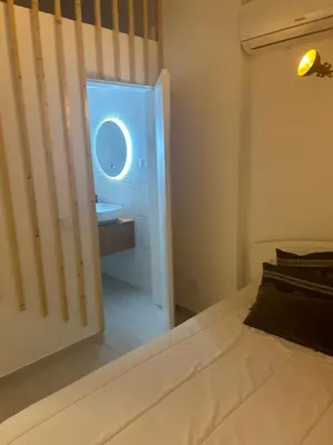 a bedroom with a bed and a bathroom with a sink at Casa das Mélias in Vilamoura