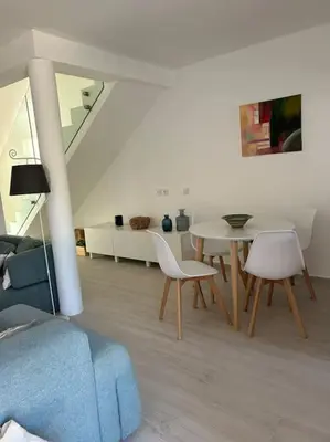 a living room with a couch and a table and chairs at Casa das Mélias in Vilamoura