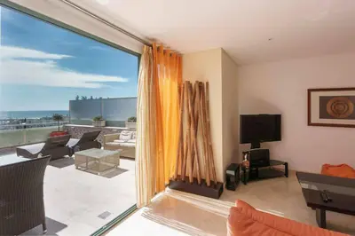 a living room with a large window and a view at VilamouraSun Aquamar Penthouse 601 in Quarteira