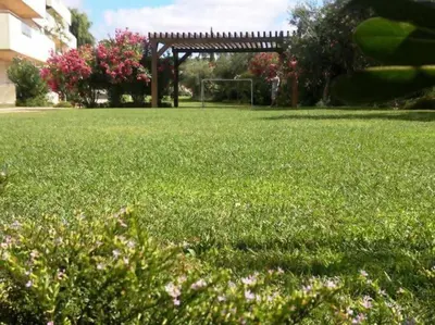 a field of green grass with a gazebo in the background at VilamouraSun Aquamar Penthouse 601 in Quarteira