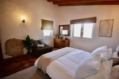 a bedroom with a large white bed and a chair at Casa Grayson in Loulé