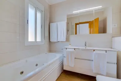 a white bathroom with a tub and a sink at Apartamento Al Sakia 2bdr com piscina e ar condicionado in Quarteira