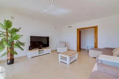a living room with a couch and a flat screen tv at Apartamento Al Sakia 2bdr com piscina e ar condicionado in Quarteira